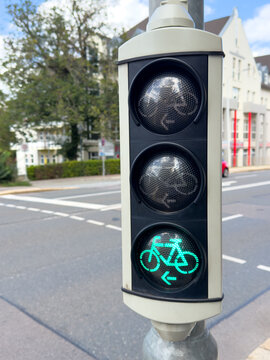 Modern bicycle traffic light showing green on a city street.