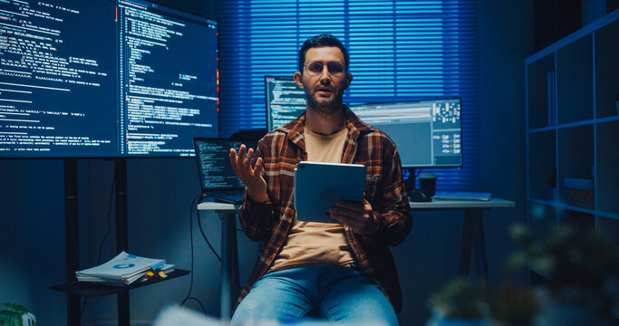 Confident Caucasian male engineer presents software strategy during late night work in office. Experienced tech consultant expertise, Innovative startup leader, Professional online conference concept.