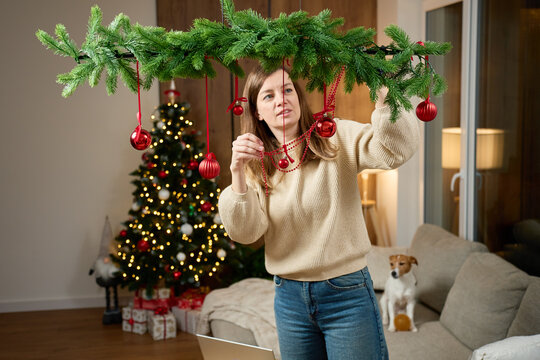 Woman decorating Christmas garland at home