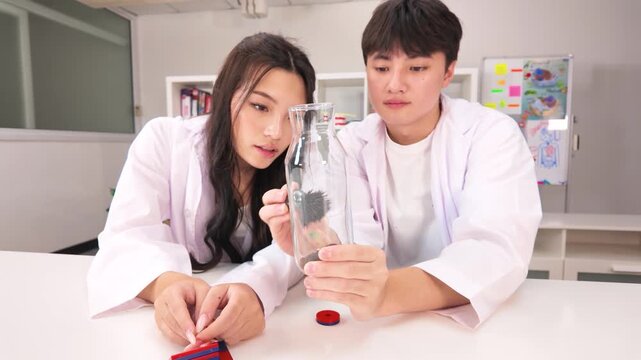 Teenage Students Conducting Magnetism Experiment with Iron Filings in Science Lab