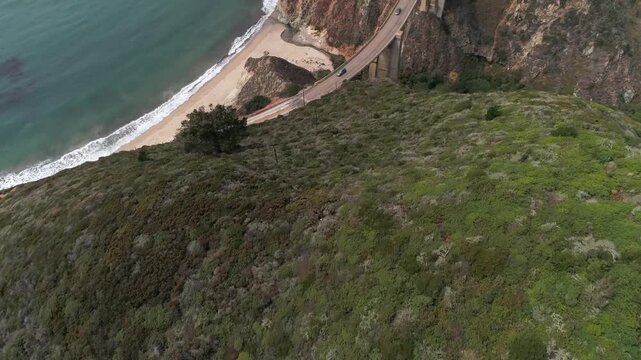 Aerial view of bixby creek bridge over canyon and rocky coastline in big sur california.