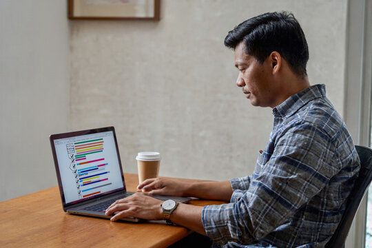 Professional man working on a project checklist at home office