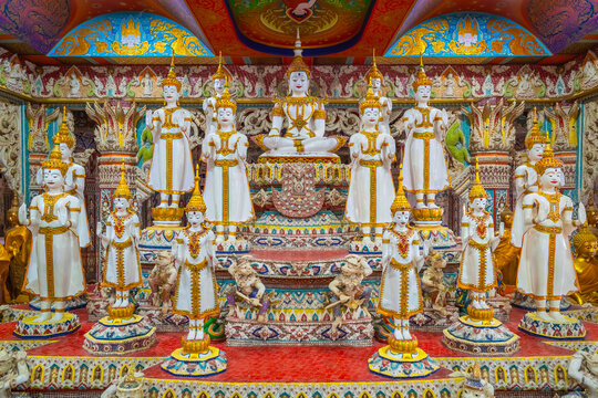 White Buddha statues with gold adornments seated and standing inside the shrine hall at Wat Sri Uthumphon in Mueang Nakhon Sawan District, Nakhon Sawan, Thailand, rich in details.