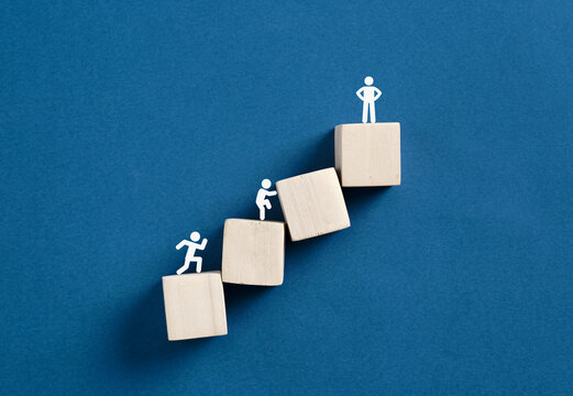 People figurines climbing wooden blocks career ladder
