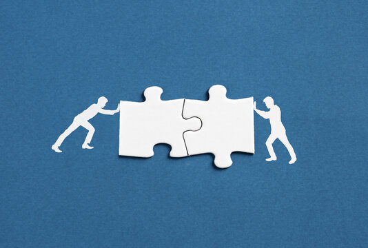 Connecting jigsaw puzzle pieces representing business collaboration and teamwork