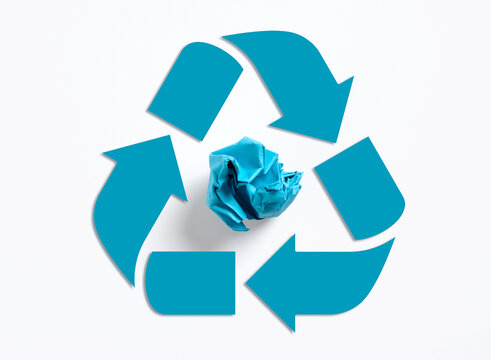 Crumpled paper inside a blue recycle symbol