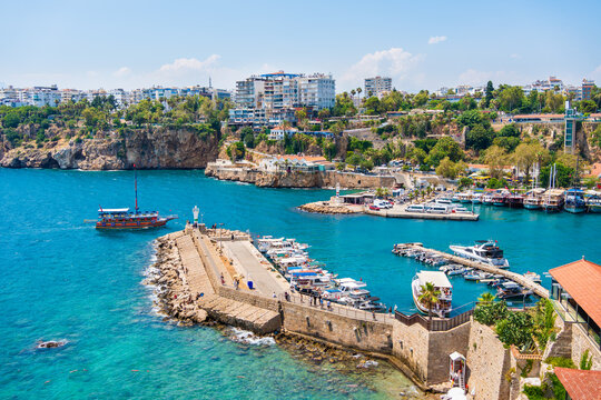 Tourist ships and fishing boats in the port of Old Town in Antalya, Turkey. Blue sea and the blue sky at sunny day.
