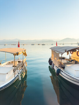 Fishing boats moored on the pier in Fethiye, Turkey.. Blue sea and the blue sky at sunrise.