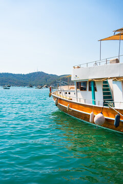 Tourists boats moored on the pier in Fethiye, Turkey.. Blue sea and the blue sky at sunny day.