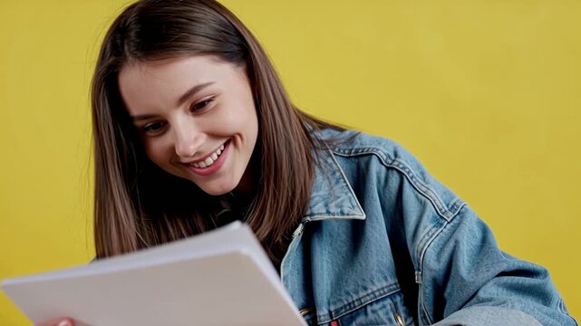 Young woman animator in an oversized denim jacket studying an unse