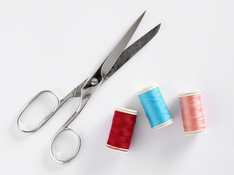 Scissors and colorful spools of thread for sewing
