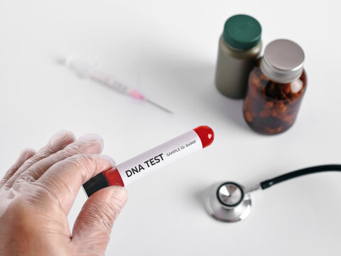 Hand holding DNA test tube for genetic analysis