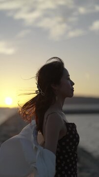 夕暮れの海にいる女性