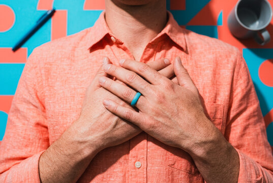 Man with hands on chest wearing a blue silicone ring