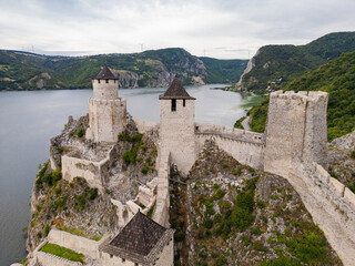 Fototapeta premium Scenic aerial drone view of the medieval Golubac Fortress built on a rocky cliff overlooking the Danube River at the entrance to Iron Gate Gorge in Serbia. Golubac, Serbia 20.07.2026