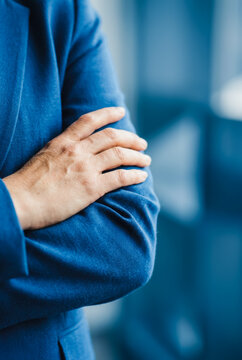Person with arms crossed wearing a blue blazer