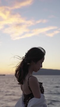 夕暮れの海にいる女性