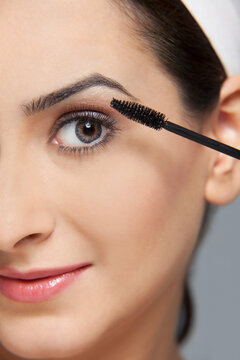 Beautiful woman applying mascara
