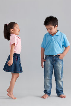 Girl trying to be taller than her brother