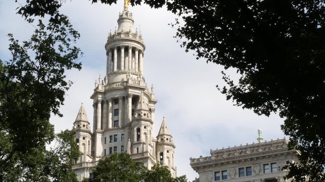 New York City Downtown Civic Center, United States of America. Manhattan municipal building 1914, old historic architecture. Government administration authority from City Hall park. Tree leaves.