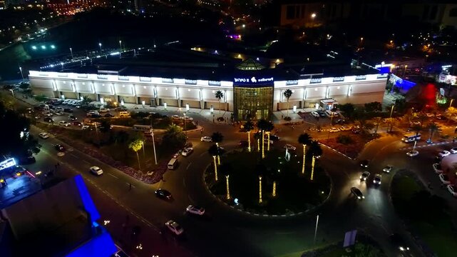 Beautiful aerial night panorama of Kish Island promenade and sea with colorful lights reflecting on water creating magical atmosphere.