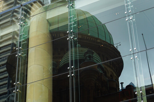 Modern glass facade reflecting historic architecture of Queen Victoria Building in Sydney