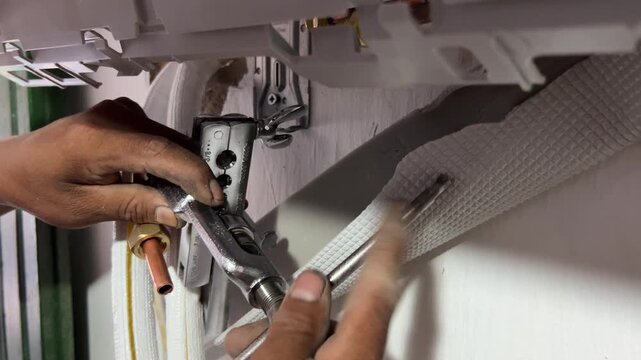 Technician using flaring tool on copper pipe during AC installation