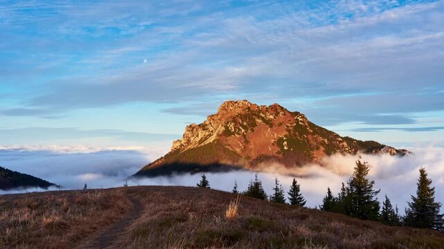Morning Panning Timelapse of Rocky Mountain Peak Over Sea of Fog with small Moon