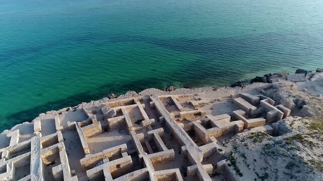 Scenic drone footage of pristine turquoise sea and sandy beach on Kish Island with gentle waves.