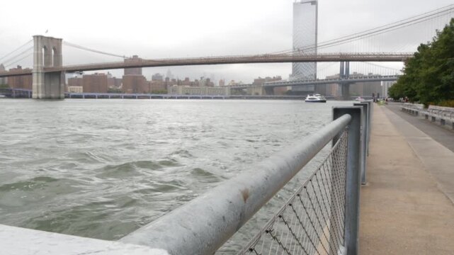 Brooklyn Bridge, Manhattan Bridge from Brooklyn Bridge park, New York City Dumbo, United States. American architecture, famous tourist landmark. Waterfront promenade, riverside esplanade perspective.