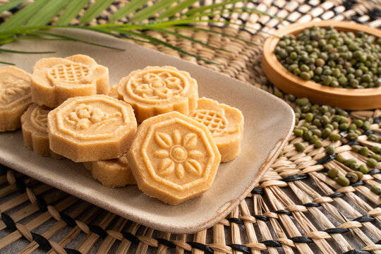 Traditional Chinese peanut mung bean cake with floral patterns on a ceramic plate.