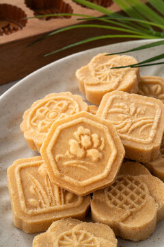 Traditional Chinese peanut mung bean cake with floral patterns on a ceramic plate.