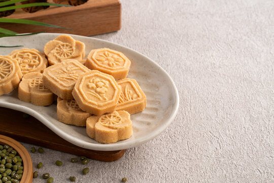 Traditional Chinese peanut mung bean cake with floral patterns on a ceramic plate.