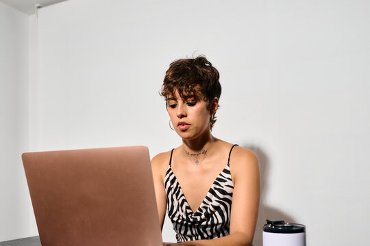 Businesswoman working at Office. DIrect flash shot. She focuses intently on her laptop screen, fingers poised over the keyboard. 