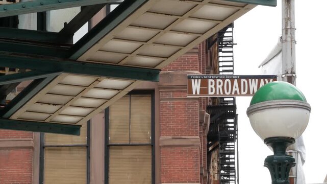 New York West Broadway street sign in Lower Manhattan, United States. Urban road sign in american city, traffic sign in NYC. Architecture of Tribeca district. Subway entrance green globe, orb lamp.