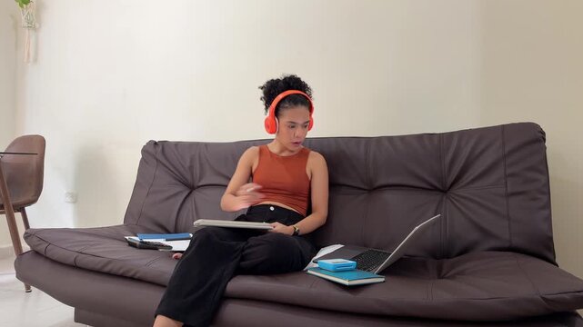 Young female student multitasking while studying from home