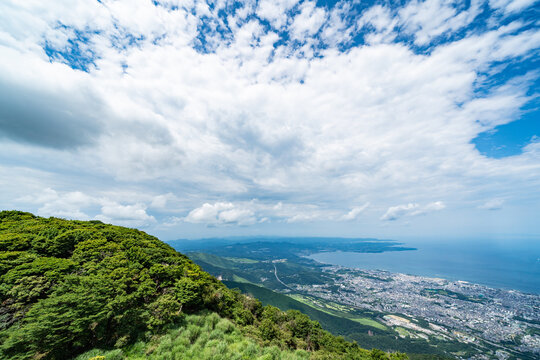 Panoramic aerial view of Beppu city and Beppu bay under blue sky with clouds from mountain viewpoint in Oita Japan