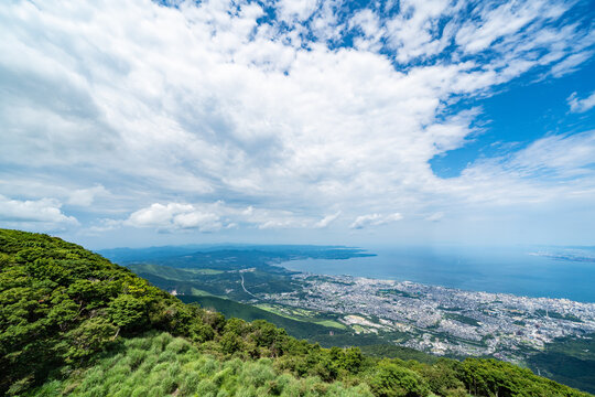 Panoramic aerial view of Beppu city and Beppu bay under blue sky with clouds from mountain viewpoint in Oita Japan