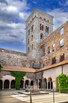 Inner cloister of Sant Pere de Rodes, Catalonia, Spain, view with tower. Sunny daylight, historic Romanesque style