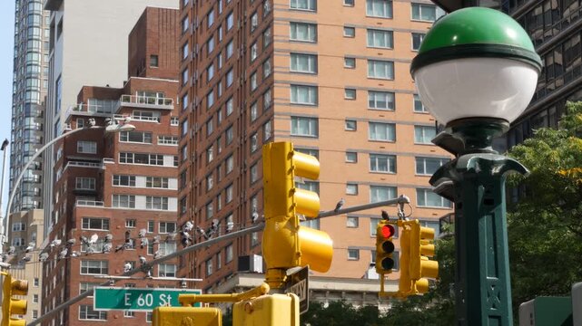 New York City 60 street sign in Manhattan Midtown, United States. Urban road sign in american city, traffic sign in NYC. Architecture of East Side. Subway entrance green globe, orb lamp. Pigeon birds.