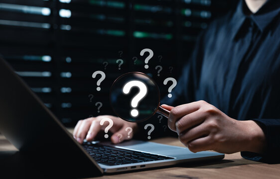 Question mark and root cause analysis concept. A hand holding a magnifying glass over large question marks surrounded by smaller ones symbolizes cause analysis and problem-solving. solution, analyze,