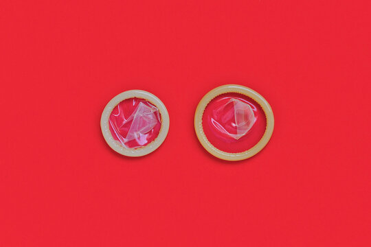 Two rolled condoms showing large and small sizes. Condom size comparison
