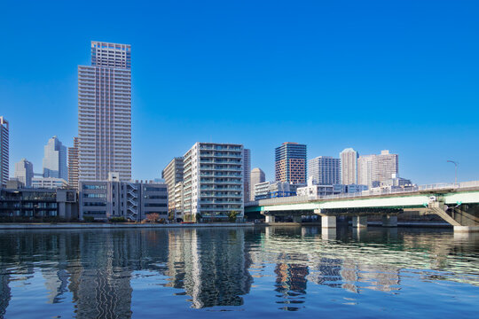 運河の水面に映る高層マンション群と青空の美しい景観