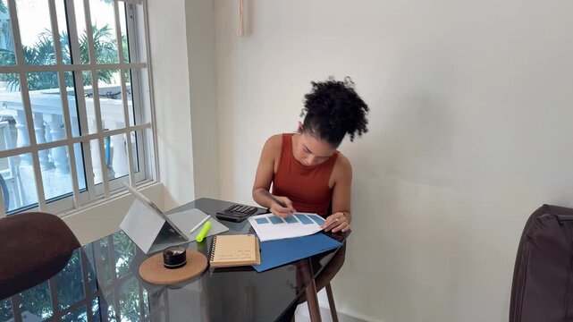 Young businesswoman analyzing financial charts working from home office