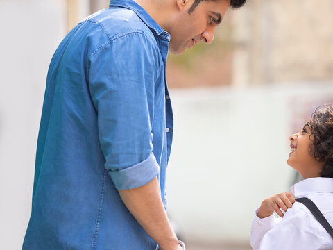 Portrait of school boy standing with his father