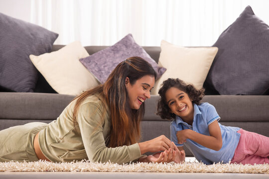Mother and Son together lying down on carpet and smiling 