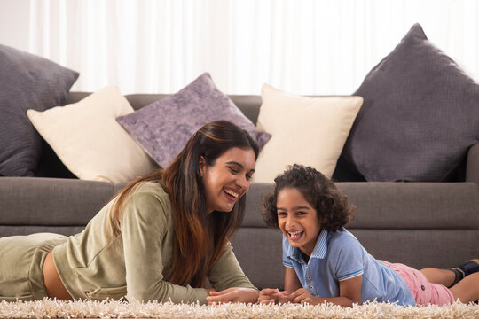 Mother and Son together lying down on carpet and smiling 