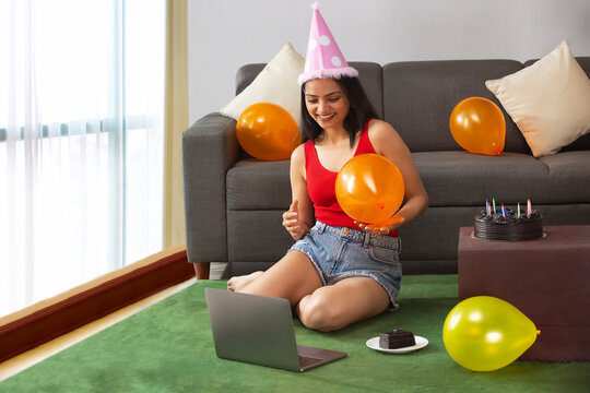 Young woman celebrating her birthday with friends virtually using online video call with laptop