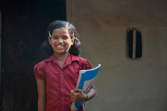 rural girl holding books ready for school. India