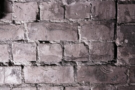 Worn weathered old brick wall texture with cracks and mortar